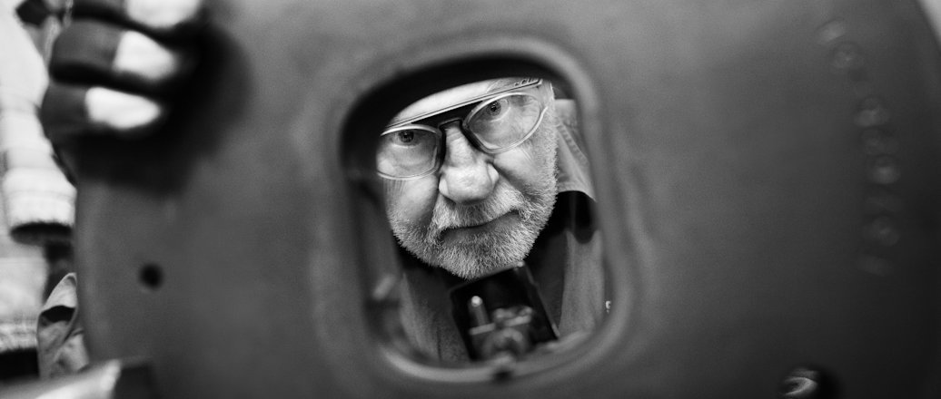 Worker looking through steel die