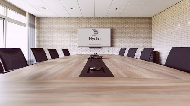 Conference room with large table, chairs and a monitor