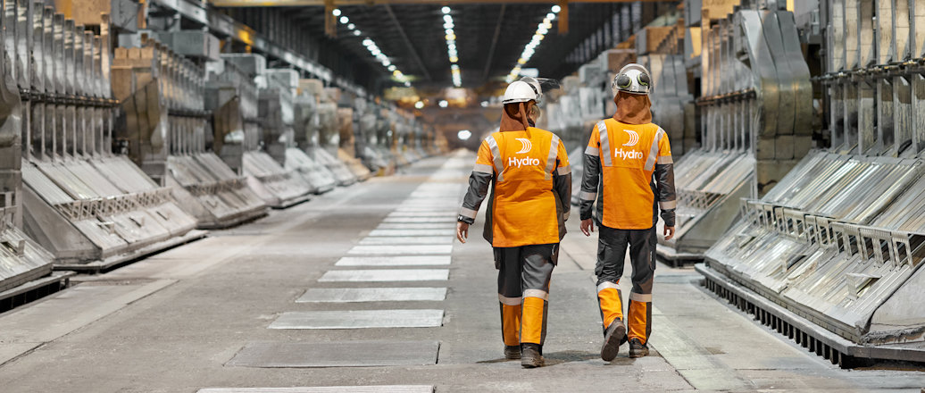 men in safety vests in a factory