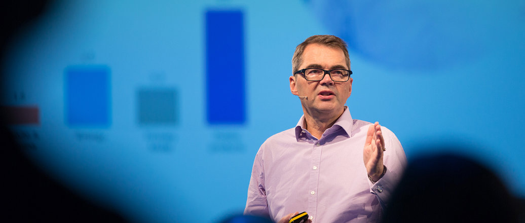 a man speaking in front of a blue screen