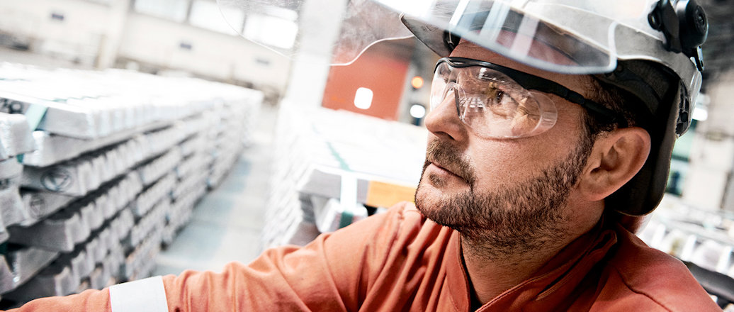 worker with stacks of aluminum bars