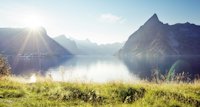 a body of water with mountains in the background with Milford Sound in the background