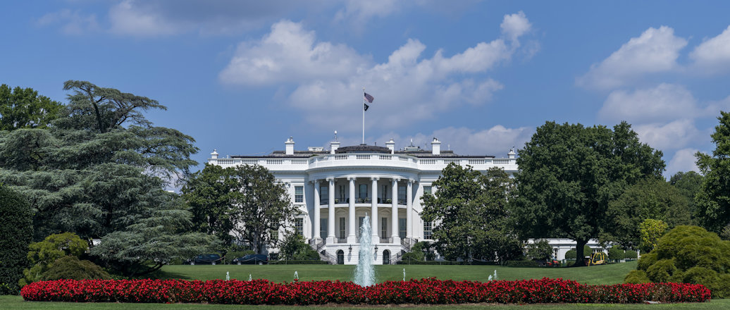 a white house with a flag on top with White House in the background