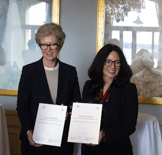 two woman holding papers