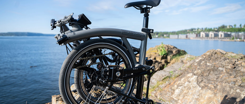 a bicycle parked on a rock by the water