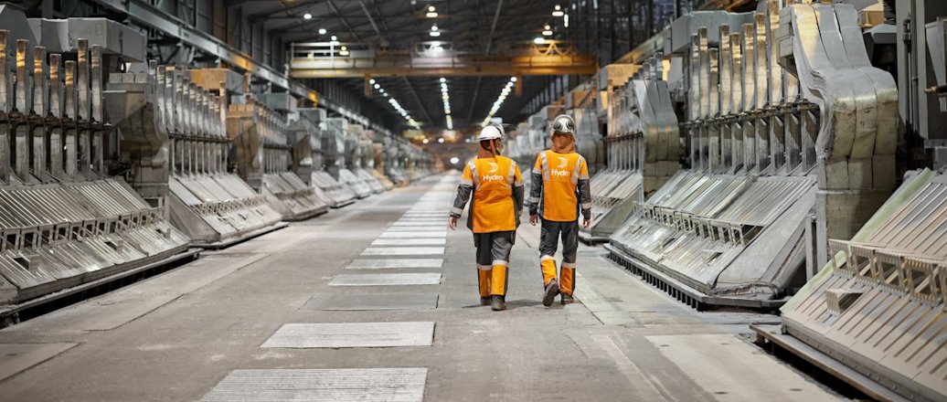 a few men in safety vests in a factory