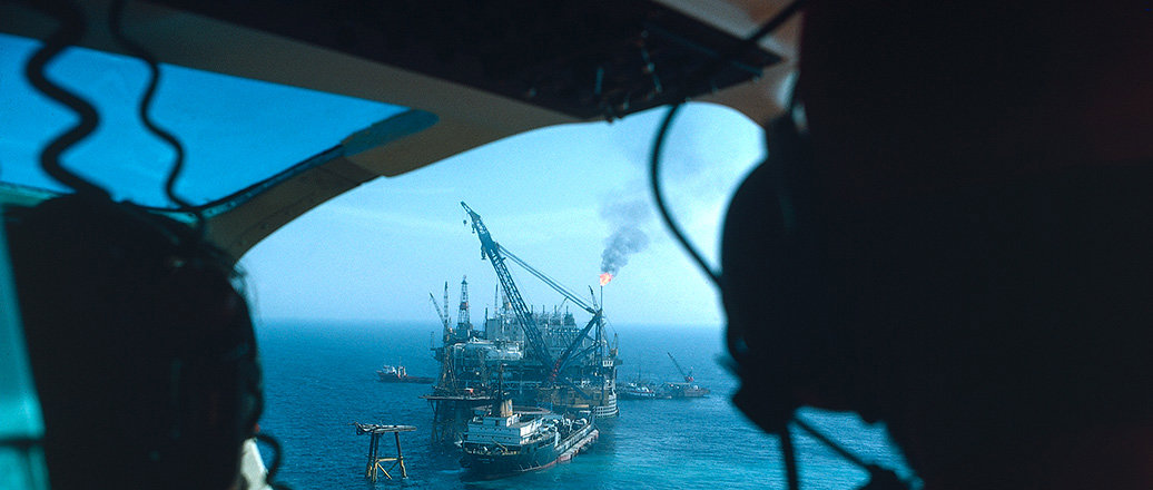 View of marine oil rig and tankers from helicopter cockpit