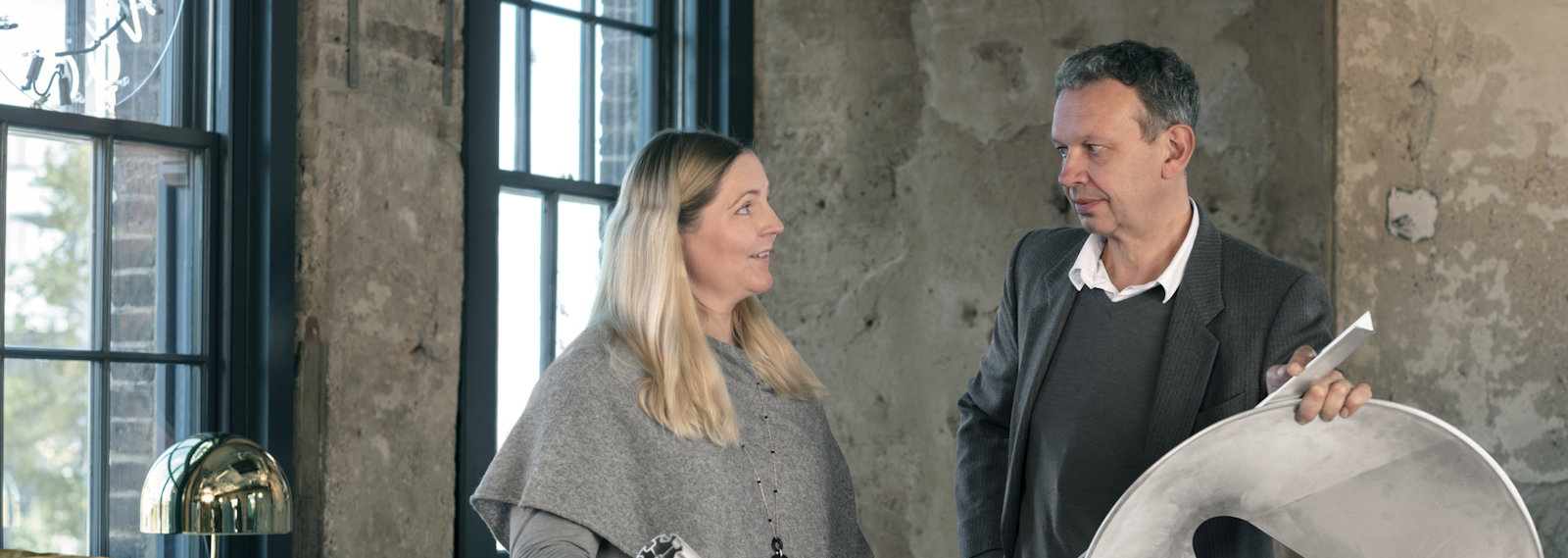 a man and woman holding large white drums